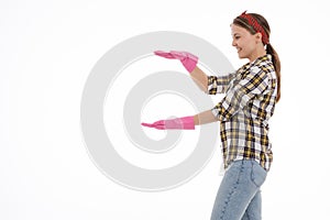 Portrait of happy female doing house duties wearing rubber gloves and holding cleaning equipment. Cheerful look. Hygiene, cleaning