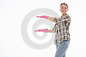 Portrait of happy female doing house duties wearing rubber gloves and holding cleaning equipment. Cheerful look. Hygiene, cleaning