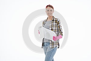 Portrait of happy female doing house duties wearing rubber gloves and holding cleaning equipment. Cheerful look. Hygiene, cleaning