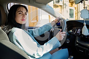 Portrait of happy female driver, beautiful confident Caucasian woman, steering car with safety belt. Driving concept