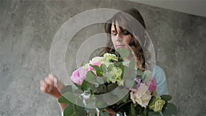 Portrait of happy female florist with bouquet roses and peone looking at camera