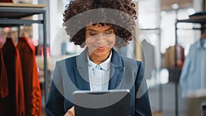 Portrait of a Happy Female Merchandising Manager Using Tablet Computer at a Stylish Clothing Store