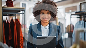 Portrait of a Happy Female Merchandising Manager Using Tablet Computer at a Stylish Clothing Store