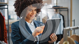 Portrait of a Happy Female Merchandising Manager Using Tablet Computer at a Stylish Clothing Store