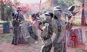 Portrait of happy female paintball players with marker guns outd