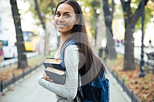 Portrait of a happy female student holding books