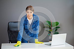 Portrait of happy female worker cleaning computer desk
