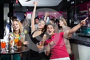 Portrait of happy females and males in the bar