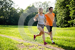 Portrait of happy fit people running together ourdoors. Couple sport healthy lifetsyle concept