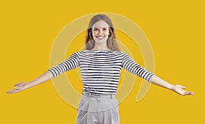 Portrait of a happy, friendly woman smiling and spreading her arms wide open for a hug
