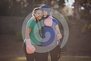 Portrait of happy friends embracing each other during obstacle course