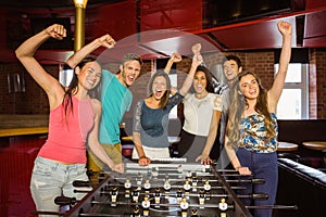 Portrait of happy friends playing table football