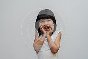 Portrait of happy and funny Asian child girl on white background, a child looking at camera. Preschool kid dreaming fill with