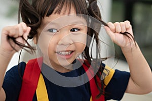 Portrait of happy and funny Asian child girl on white background, a child looking at camera. Preschool kid dreaming fill with