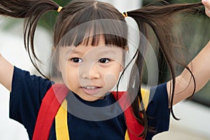 Portrait of happy and funny Asian child girl on white background, a child looking at camera. Preschool kid dreaming fill with
