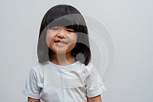 Portrait of happy and funny Asian child girl on white background, a child looking at camera. Preschool kid dreaming fill with