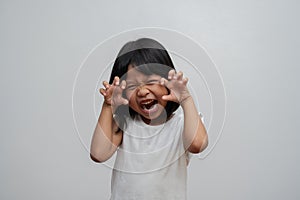 Portrait of happy and funny Asian child girl on white background, a child looking at camera. Preschool kid dreaming fill with