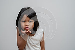 Portrait of happy and funny Asian child girl on white background, a child looking at camera. Preschool kid dreaming fill with