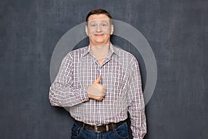 Portrait of happy funny man raising thumb up in like gesture