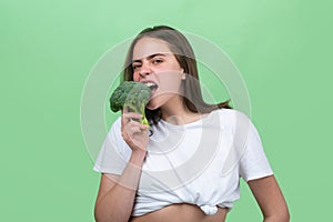 Portrait of happy funny young beautiful woman eating broccoli. Healthy food, health life. Raw diet.