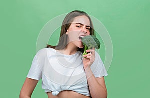 Portrait of happy funny young beautiful woman eating broccoli. Healthy food, health life. Raw diet.