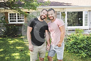 A Portrait of a happy gay couple outdoors in front of a new buy