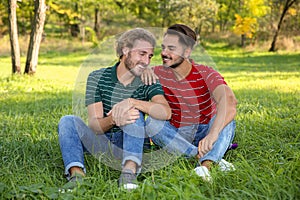Portrait of happy gay couple sitting on grass