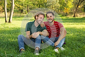 Portrait of happy gay couple sitting on grass