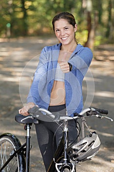 Portrait happy girl biker with showing thumbs up