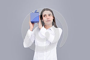 Portrait of a happy girl with gift box isolated over gray background. Woman holding gift present.