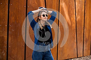 Portrait of a happy girl listening music on line with headphones from a smartphone in the street in a summer sunny day. Woman list