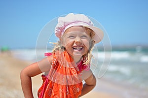 Portrait of happy girl in orange dress on the beach