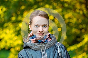 Portrait of happy girl over foliage background at autumn day