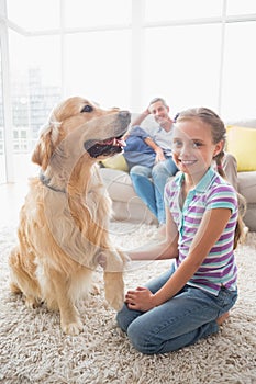 Portrait of happy girl playing with dog at home