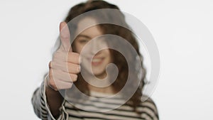 Portrait of happy girl showing thumbs up on white. Woman showing thumb up