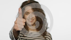 Portrait of happy girl showing thumbs up on white. Woman showing thumb up