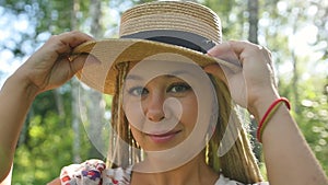 Portrait of a happy girl who walks in the summer forest in the morning sun