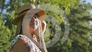 Portrait of a happy girl who walks in the summer forest in the morning sun