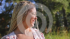 Portrait of a happy girl who walks in the summer forest in the morning sun