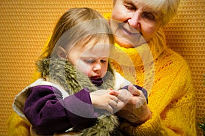 Portrait of happy grandmother hugging her granddaughter over Christmas presents and decorated New Year tree, merry