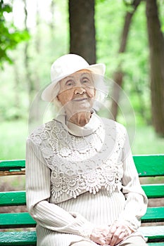 Portrait of happy grandmother on a park bench,