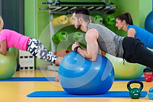 Portrait of happy group exercising on Swiss ball