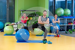 Portrait of happy group exercising on Swiss ball