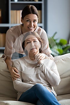 Portrait happy grownup daughter hugging pleasant mother.