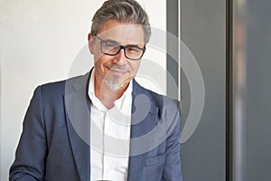 Portrait of happy handsome man wearing glasses, looking at camera. Confident businessman in suit, using tablet