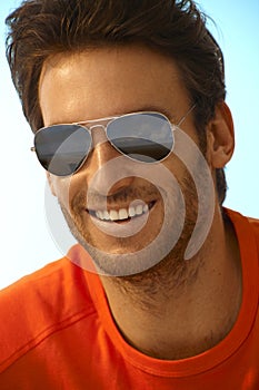 Portrait of happy handsome man wearing sunglasses photo