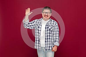 Portrait of happy handsome middle aged business man in casual checkered shirt, eyeglasses standing looking at camera, waving his