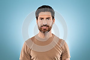 Portrait of happy handsome middle aged man posing isolated over blue studio background and smiling at camera