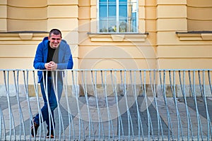 Portrait of a happy handsome young man in an urban street who is smiling and looking at the camera.