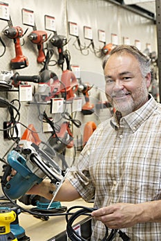 Portrait of a happy hardware store owner with electric saw photo